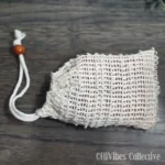 Natural sisal soap saver bag with drawstring closure holding a bar of handmade soap