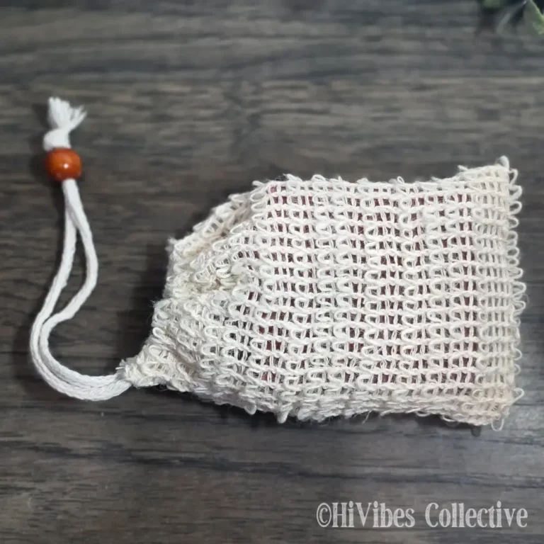 Natural sisal soap saver bag with drawstring closure holding a bar of handmade soap