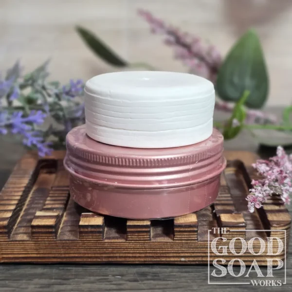 Sun & Shield natural sunscreen bar resting on a travel tin, showing its smooth solid texture