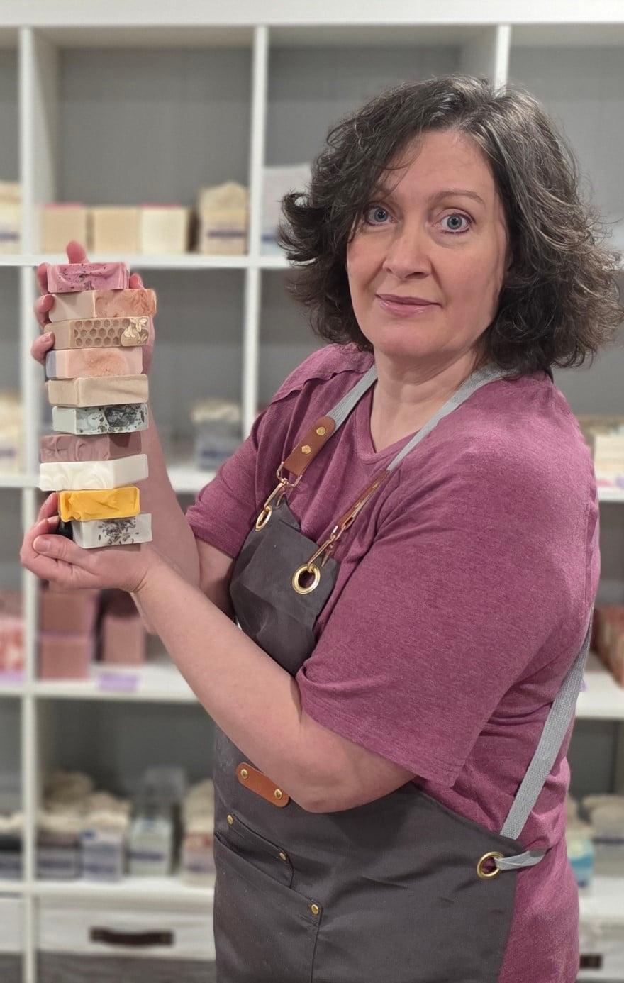 Kim, the owner, holding a stack of handmade soap.