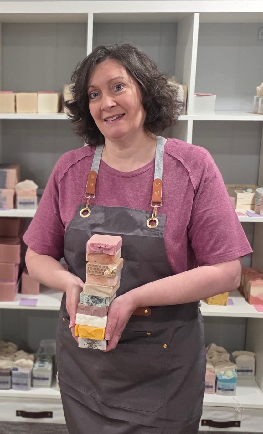 Kim, the owner, holding a stack of handmade soap.