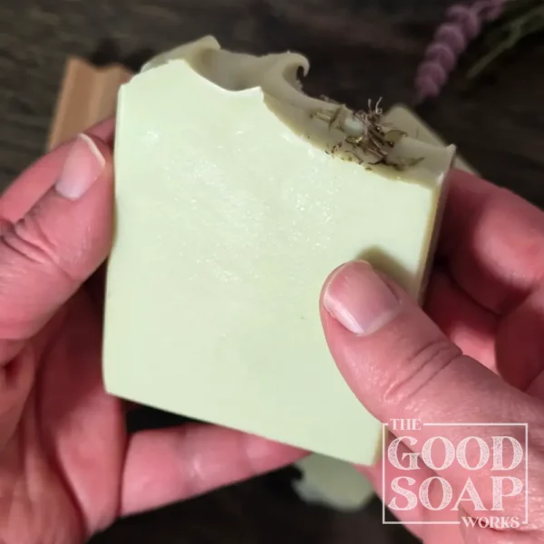 Herbalist's Tallow Soap in hand showing Side and Top View