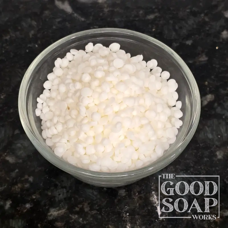 BTMS-50 pastilles displayed in a small bowl, an emulsifying ingredient used in skincare by The Good Soap Works Co.