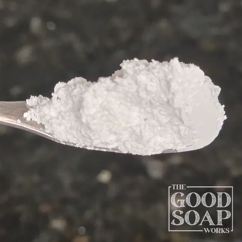 Close-up of Calcium Carbonate powder on a spoon, an ingredient used in soap and skincare by The Good Soap Works Co.