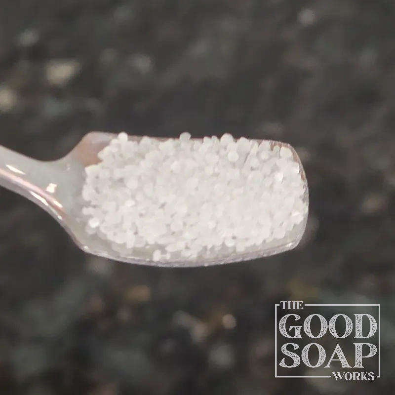 Close-up of Citric Acid powder on a spoon, a pH-adjusting ingredient used in soap and skincare by The Good Soap Works Co.