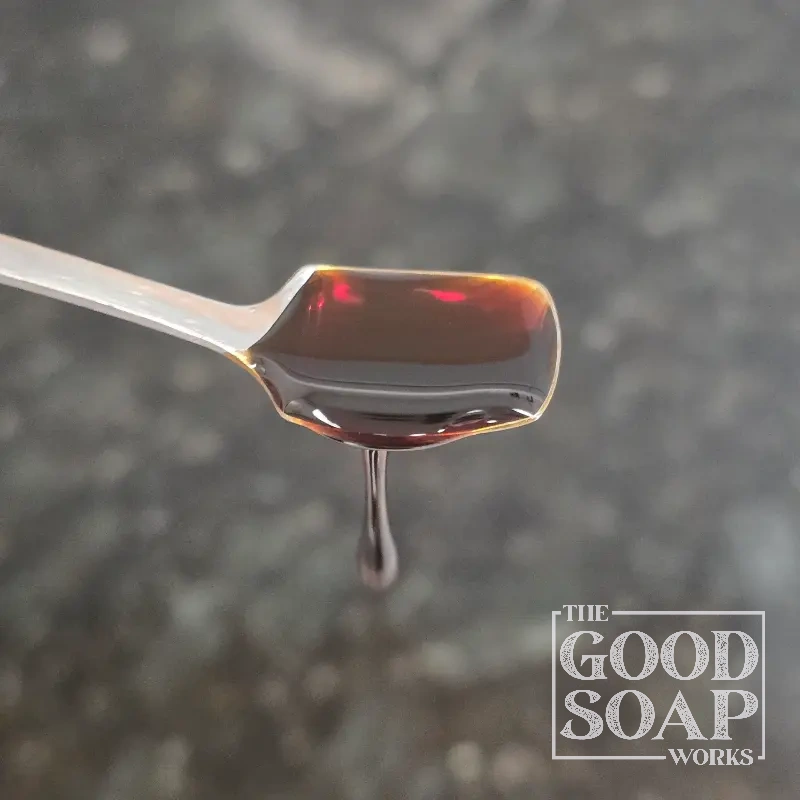 Pine tar on a wooden spoon — a traditional wood-derived ingredient used in old-fashioned pine tar soap