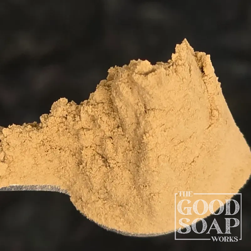 Rhassoul clay on a wooden spoon — a traditional Moroccan mineral clay used in natural soap and hair care