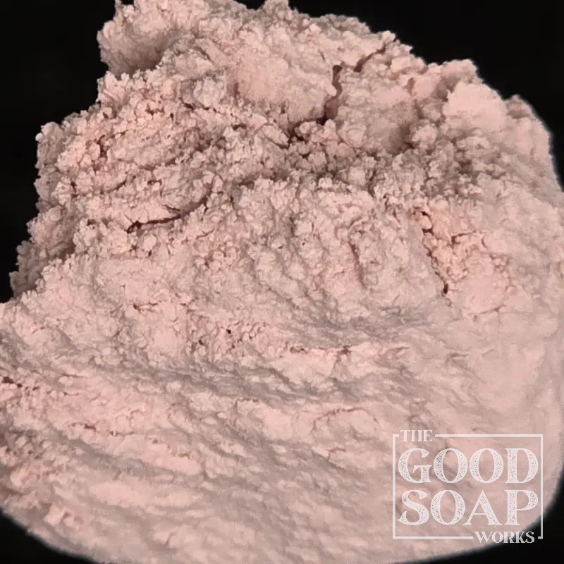 Rose clay powder on a wooden spoon — a soft pink mineral clay used in natural soap and facial care