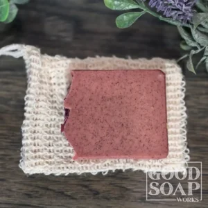 Sisal soap saver bag shown next to a full bar of handmade soap for size reference