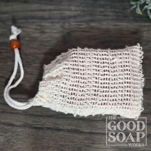 Natural sisal soap saver bag with drawstring closure holding a bar of handmade soap