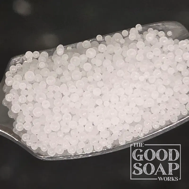 Sodium hydroxide lye beads on a spoon — the essential alkali used in cold process soap making