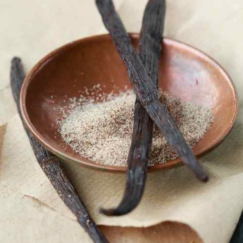 Two whole vanilla beans with caviar displayed in a small bowl, a natural aromatic ingredient used in soap and skincare by The Good Soap Works Co.