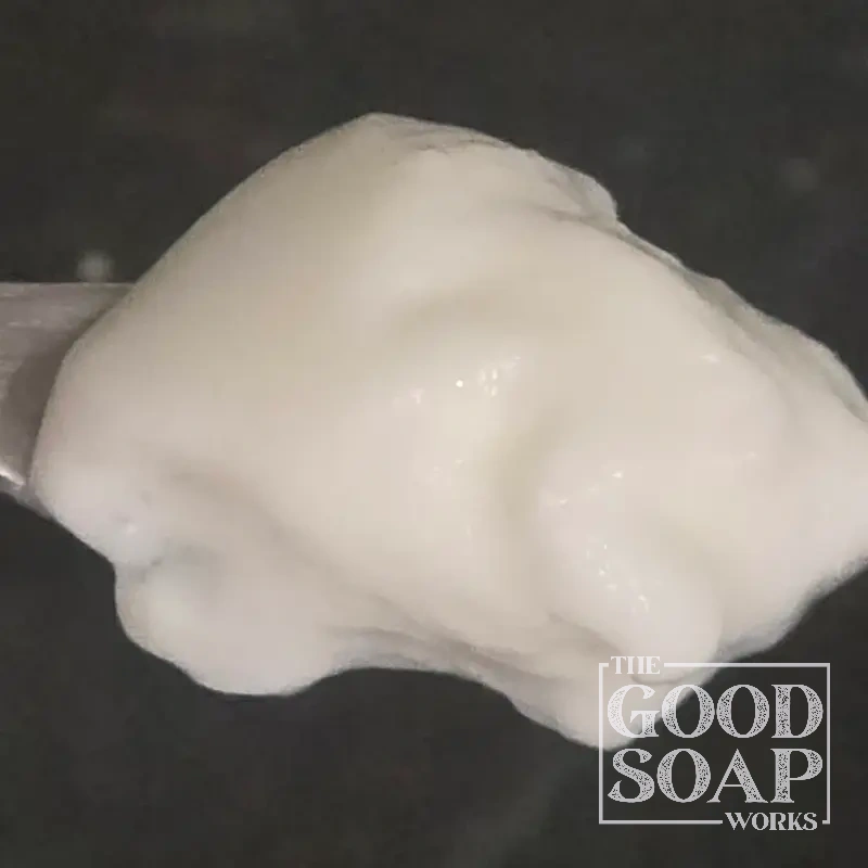 Yogurt on a wooden spoon — a natural soap making additive that contributes a creamy lather